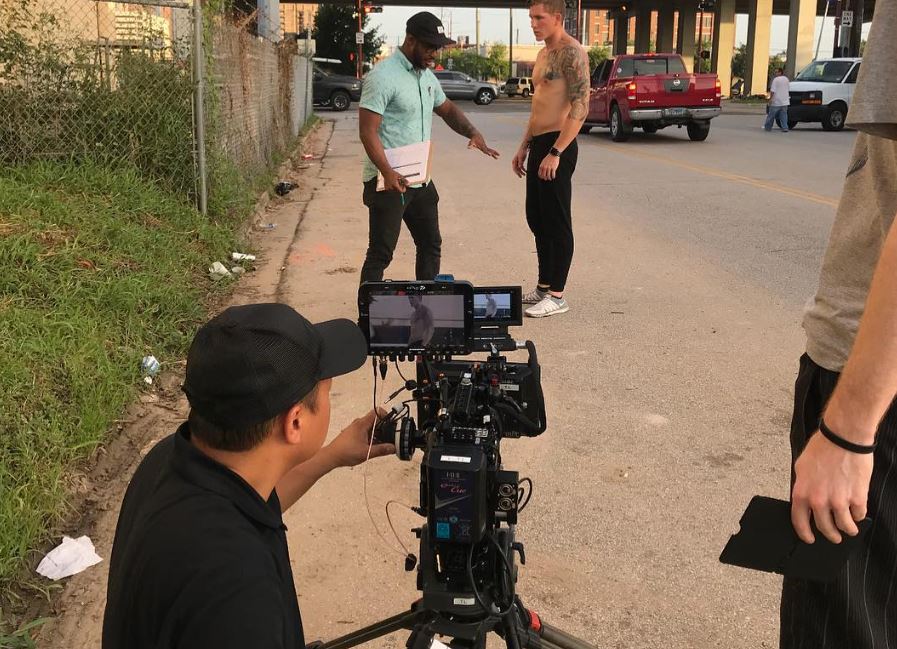 A film crew with a professional camera films two men on a street, suitable for Corporate Video Production Agency in Timber Oaks