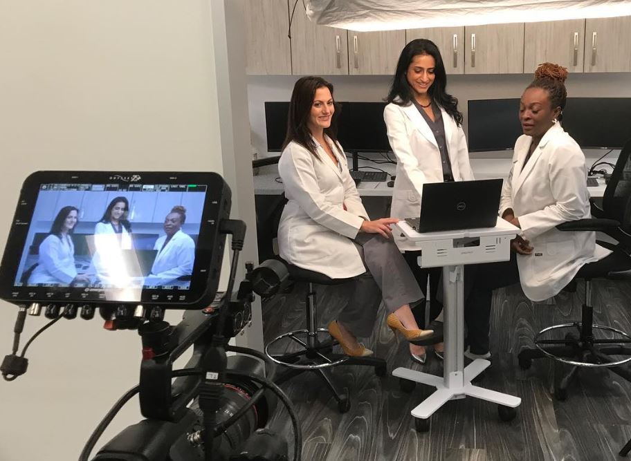 Three dentists review a laptop screen while being filmed for Dental Video Production in Spring Branch West