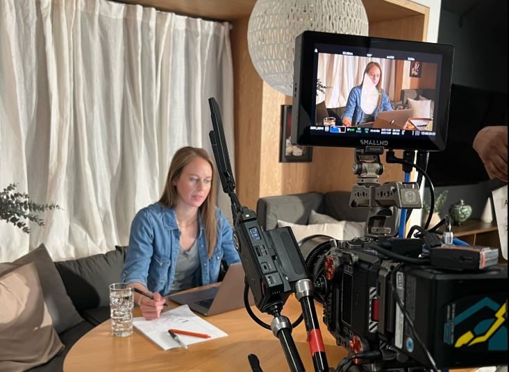 A professional camera setup films a woman working on a laptop at a table, ideal for Instructional Video Production in Memorial City
