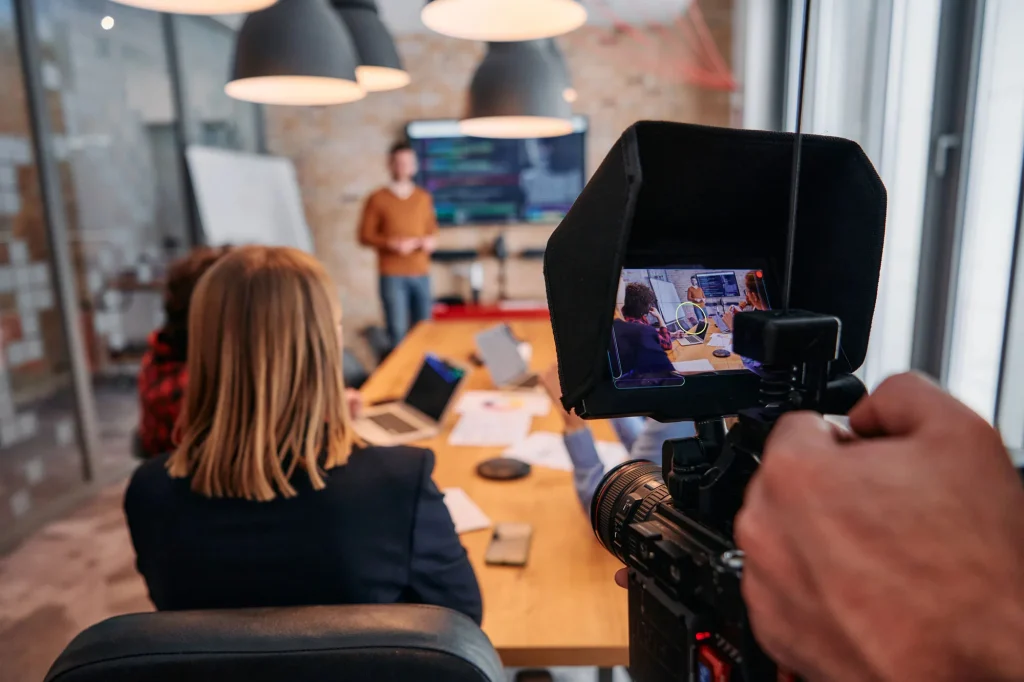 Camera capturing a presentation for a corporate video production company in Houston's modern conference room.
