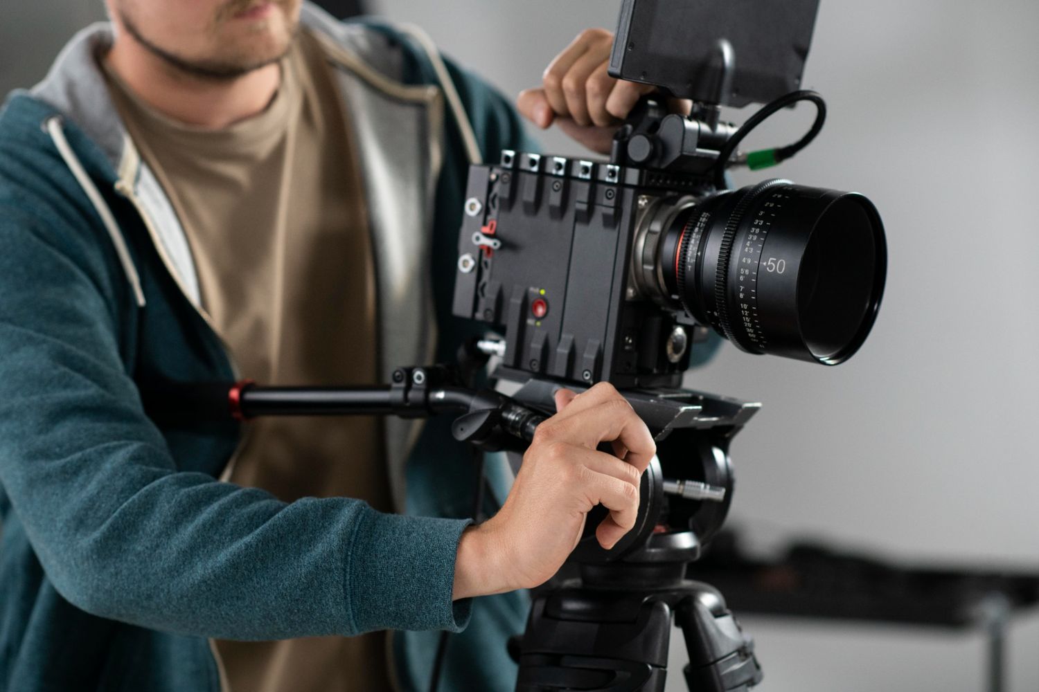 Videographer adjusting professional camera on tripod during dentist explainer video production in Houston.