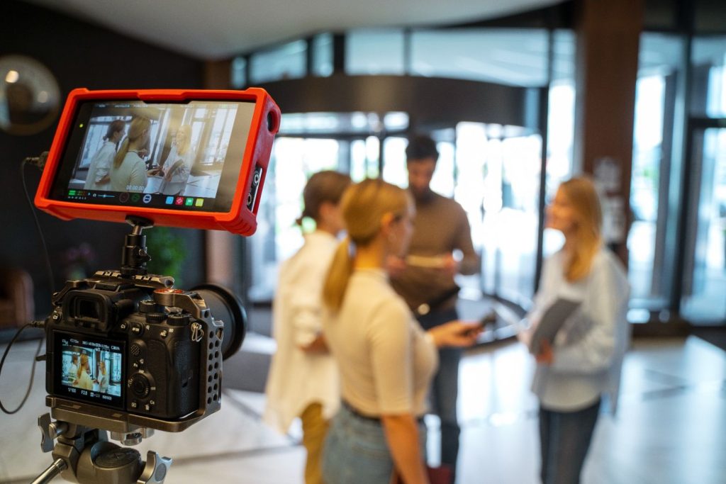 Camera setup capturing a team meeting for a commercial video production company in Houston's modern office lobby.