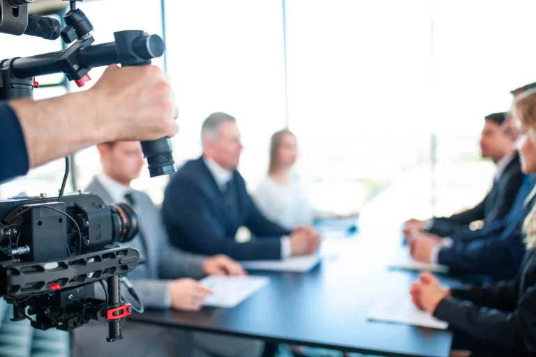 Camera filming a professional meeting for a corporate video production company in Houston's modern conference room.