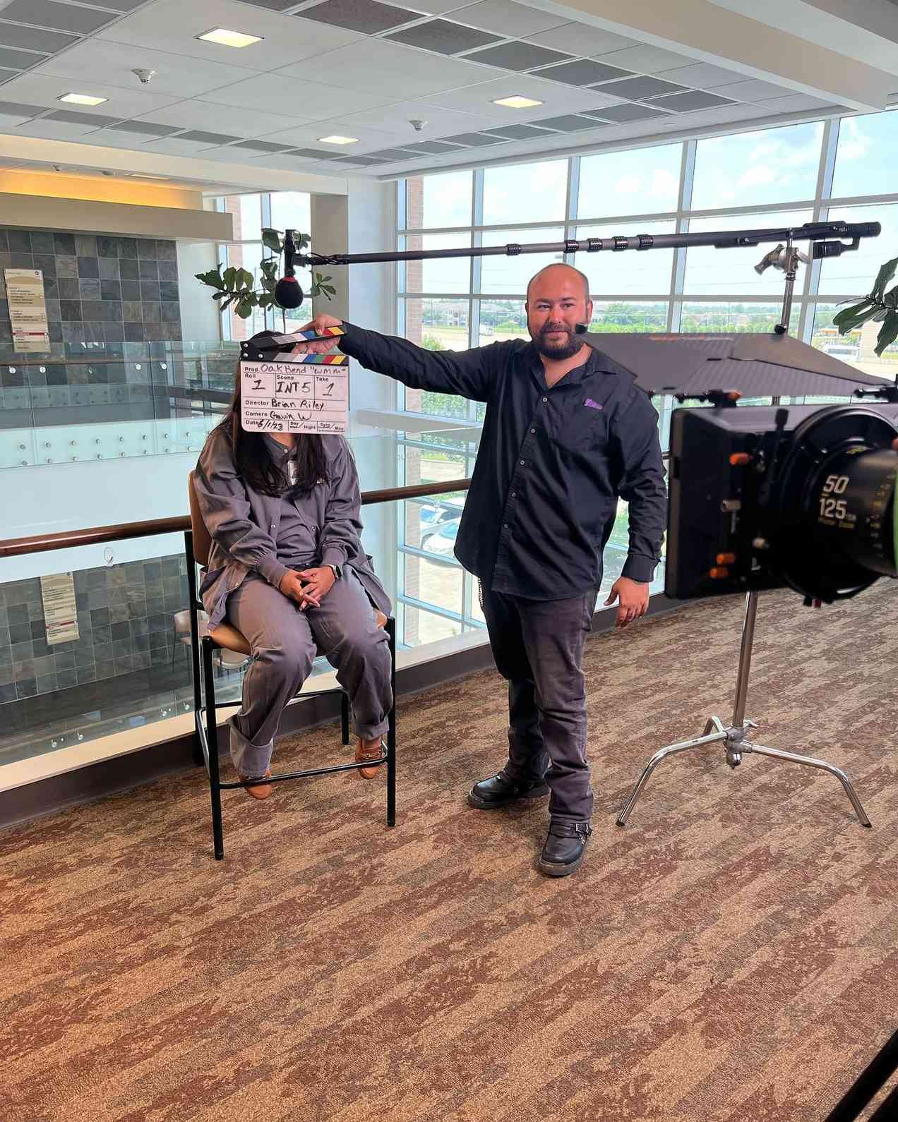 Dental video production in Houston with a director clapperboard and crew filming in a modern clinic setting.