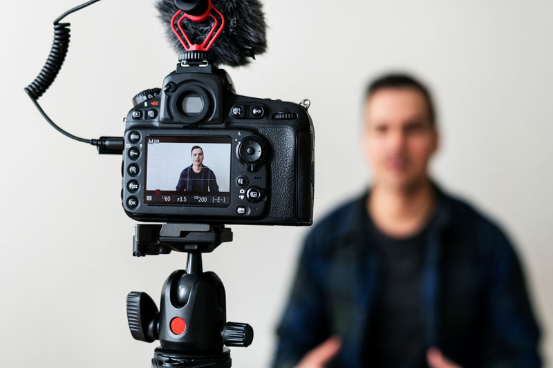 Close-up of camera recording a professional speaking in a studio setting in Houston, capturing authentic moments for dental promotional video.