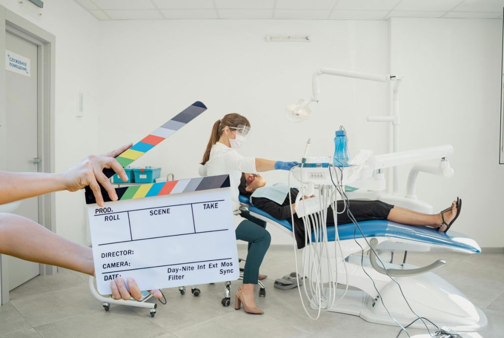 Clapperboard signaling 'Action' for high-quality Dental Video Production Houston filming a patient procedure.