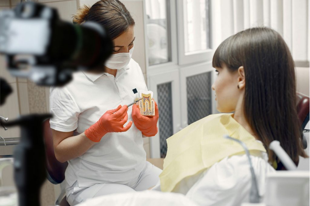 Dentist demonstrating a root canal procedure model on camera for expert Dentist Explainer Video Production Houston.