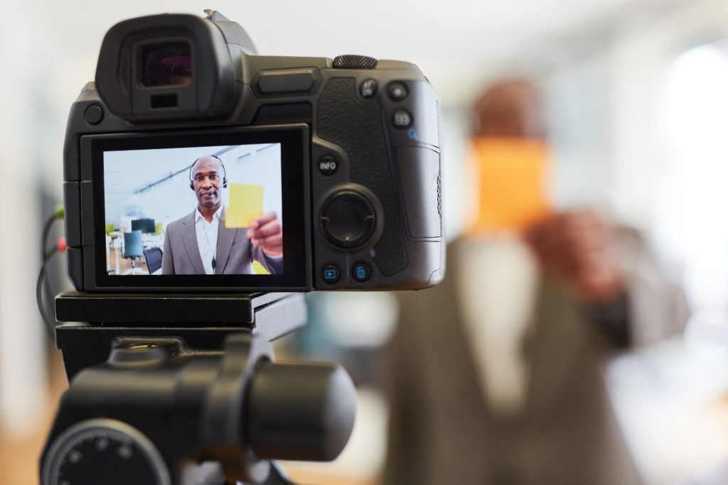 Corporate speaker recording on camera for high-quality video production services Houston. Clear on-screen review.