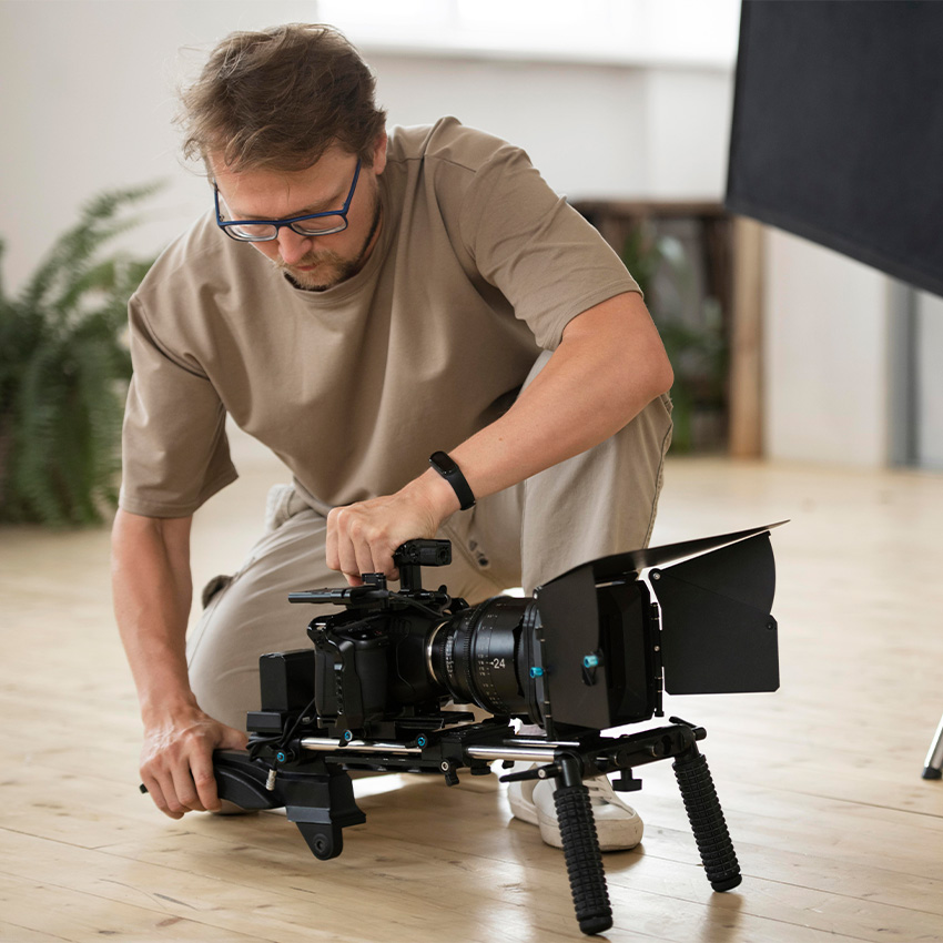 A videographer setting up a professional cinema camera rig with the best infomercial video production company Houston.