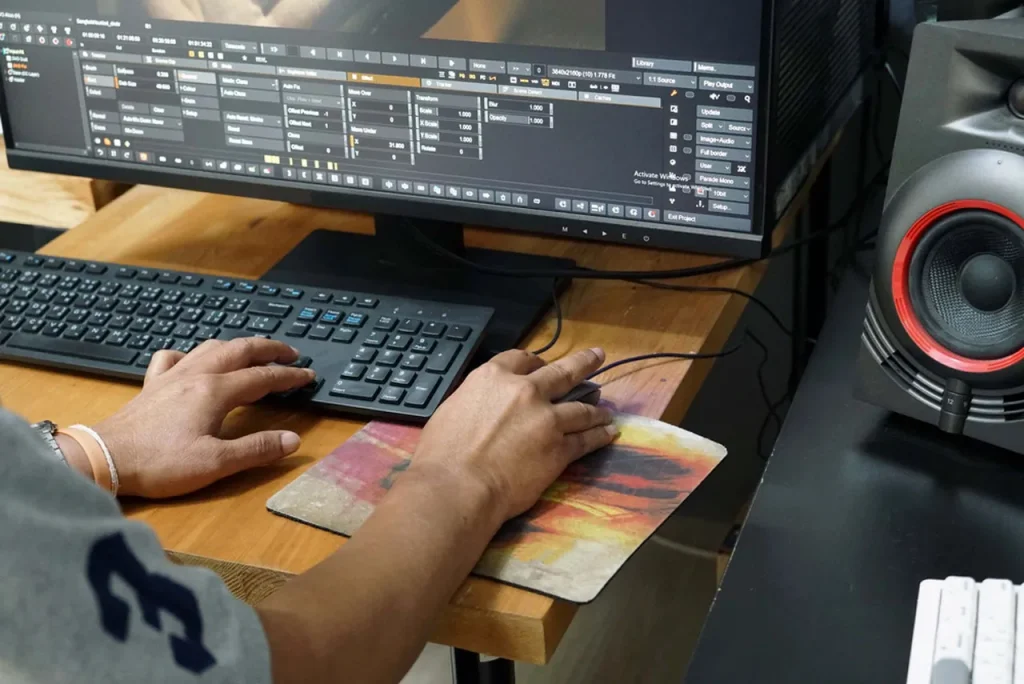 Detailed view of professional video editing software and an editor's hands at a station for a top video production company in Houston.
