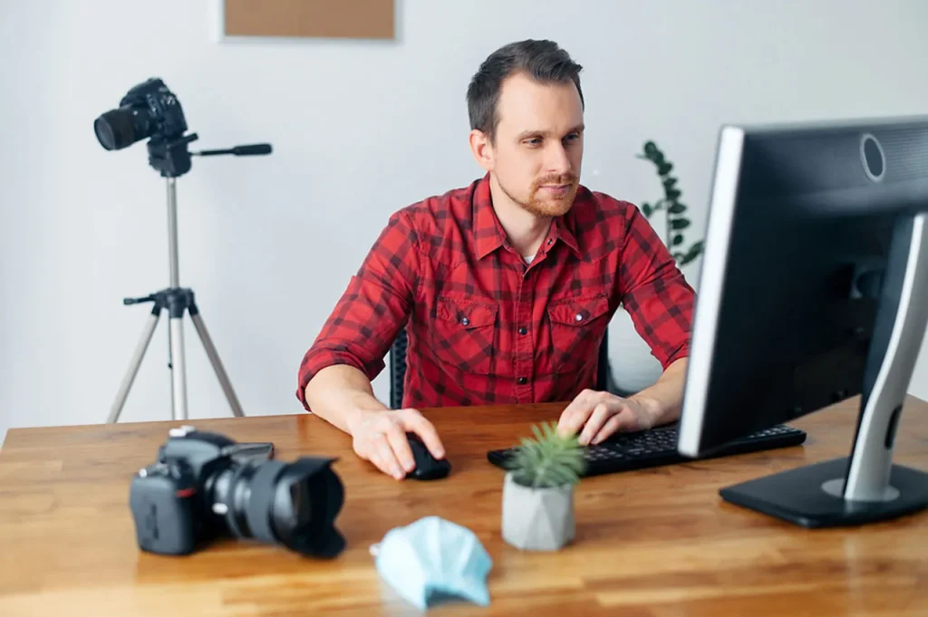 Houston video production company professional works at a post-production editing desk with camera gear, demonstrating quality services.